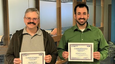 Two males holding a certificate
