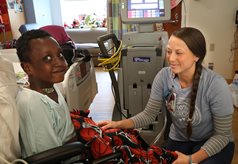 boy in hospital bed with nurse at his side